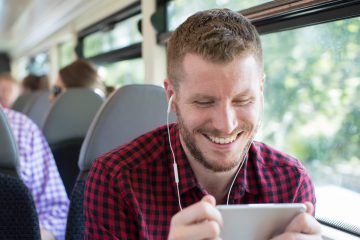 Man Watching Movie On Mobile Phone During Journey To Work